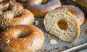 Färska bagels med sesamfrön och vallmofrön, perfekta för ditt bagels recept. En skuren bagel visar det fluffiga inre.