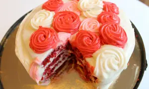 En skivad red velvet cake med fluffig frosting i rosformar.