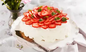 En vacker jordgubbstårta med fluffig grädde och färska jordgubbar. Tårtans fyllning är hemligheten bakom dess saftighet.