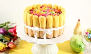 En färgglad påsktårta med lemoncurd, dekorerad med savoiardikex och geléhallon. En perfekt dessert för påskfirandet!