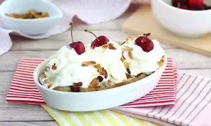 En läcker banana split med vispgrädde, körsbär och mandelflagor. En klassisk dessert som alltid går hem.
