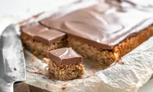 En bit av en långpanne kaka med nougat. Kakan har en krispig botten och toppas med ett lager choklad.