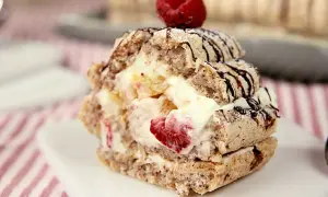 En läcker budapestbakelse med grädde och frukt, toppad med en hallon och chokladdrizzle.