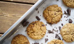 Nybakade havrekakor med chokladbitar på en plåt. Perfekt för ett enkelt havrekakor recept.