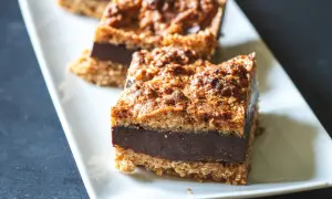 Tre sega havrerutor med chokladfyllning ligger på ett vitt fat.