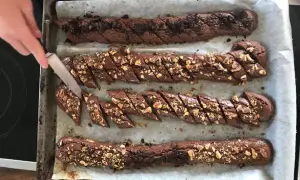Chokladsnittar recept: Nybakade chokladkakor med nötter skärs upp på en plåt.