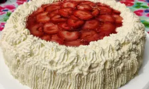En himmelsk jordgubbstårta med fluffig grädde och glaserade jordgubbar på toppen. Perfekt för sommaren!