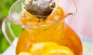 En karaff med iste, citronskivor och en tepåse som drar. Perfekt iste recept för en varm sommardag.