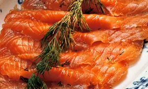 Tunna skivor av rimmad lax med dill, redo att avnjutas.