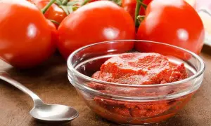 Färska tomater och en skål med tomatpuré, perfekt för ditt tomatpuré recept.
