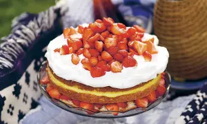 En härlig jordgubbstårta med fluffig grädde och en syrlig lemoncurdfyllning, perfekt för sommaren.
