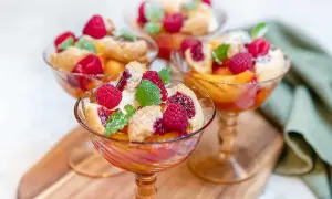 Tre eleganta glas med persika, hallon och smuldeg. En klassisk peach melba som ser ljuvlig ut.