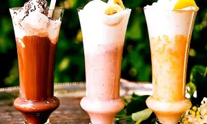 Tre läckra milkshakes i glas: choklad, jordgubb och aprikos. Perfekt för ett somrigt milkshake recept!