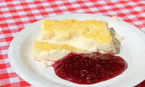 Två bitar krämig kalvdans med hallonsylt på en vit tallrik. Ett enkelt kalvdans recept för en härlig fika.