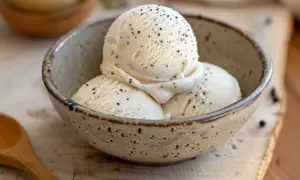 Tre kulor krämig vaniljglass med vaniljstångsfrön i en rustik skål. Perfekt för ett enkelt vaniljglass recept.