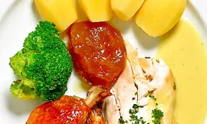 En tallrik med kyckling, potatis, broccoli och en härlig citronsås till kyckling.