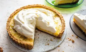 En krämig key lime pie med fluffig grädde, en bit serverad på en grön tallrik.