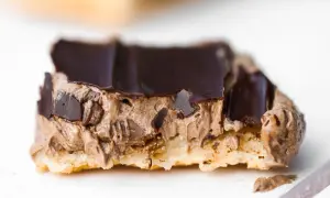 En närbild på en chokladbiskvi med krämig chokladfyllning och mörk chokladglasyr.