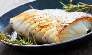En saftig bit torsk i ugn, perfekt tillagad med krispig yta och serverad med rosmarin.