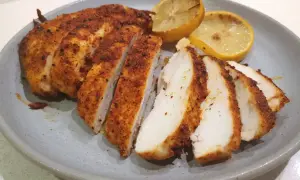 Saftig kyckling i airfryer, skivad och serverad med grillade citronklyftor. Perfekt för en snabb och god middag.