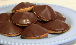 En tallrik med chokladöverdragna biskvier. Perfekt för ett enkelt biskvier recept.
