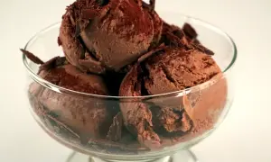En skål med krämig chokladglass, toppad med chokladspån. Perfekt för ett enkelt chokladglass recept.