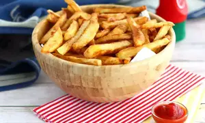 En skål med gyllene, krispiga egna pommes frites, redo att doppas i ketchup.