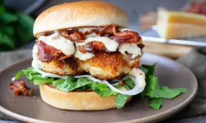 En saftig kycklingburgare med krispigt bacon och krämig dressing. Perfekt för ett hamburgerdressing recept.