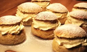 Flera gammaldags semlor med rikligt med grädde och pudrat florsocker. En klassisk svensk fika.