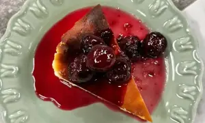En bit krämig ostkaka med körsbärssås och hela körsbär. Perfekt för ett ostkaka recept.