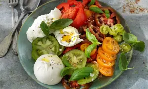 En krämig burrata med en blandning av färgglada tomater och färsk basilika. Ett enkelt och gott burrata recept.