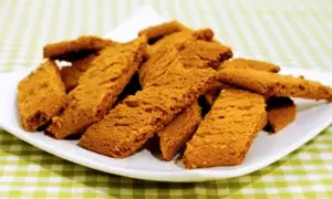 En hög med gyllene kolakakor på en vit tallrik, redo att avnjutas. Perfekt för ett enkelt kolakakor recept.