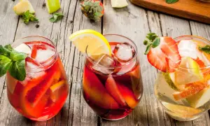 Tre glas med färgglad sangria, fyllda med frukt och is. Perfekt för ett somrigt recept sangria.