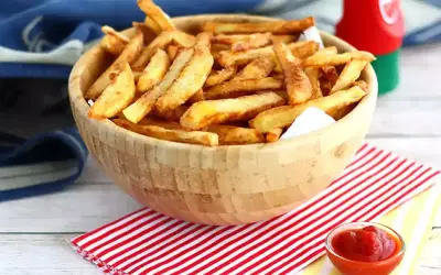 En skål med gyllene, krispiga egna pommes frites, redo att doppas i ketchup.