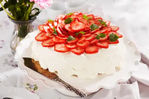 En vacker jordgubbstårta med fluffig grädde och färska jordgubbar. Tårtans fyllning är hemligheten bakom dess saftighet.