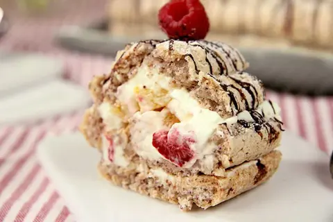 En läcker budapestbakelse med grädde och frukt, toppad med en hallon och chokladdrizzle.