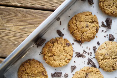 Nybakade havrekakor med chokladbitar på en plåt. Perfekt för ett enkelt havrekakor recept.
