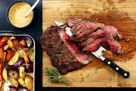Saftig flankstek i ugn, skivad och serverad med ugnsrostade rotfrukter och en krämig sås. Perfekt middag!
