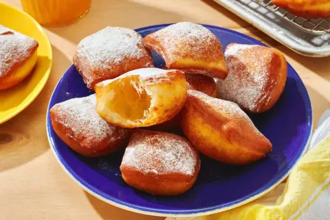 Färska, fluffiga beignets pudrade med florsocker. Ett perfekt beignets recept för hembakning.