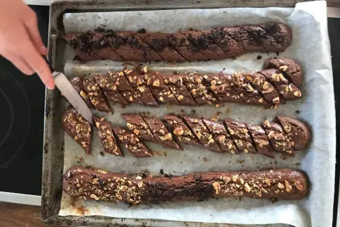 Chokladsnittar recept: Nybakade chokladkakor med nötter skärs upp på en plåt.