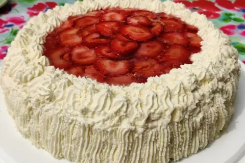 En himmelsk jordgubbstårta med fluffig grädde och glaserade jordgubbar på toppen. Perfekt för sommaren!