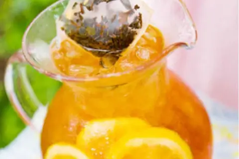 En karaff med iste, citronskivor och en tepåse som drar. Perfekt iste recept för en varm sommardag.