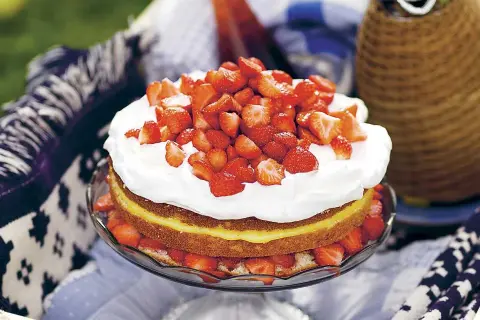 En härlig jordgubbstårta med fluffig grädde och en syrlig lemoncurdfyllning, perfekt för sommaren.