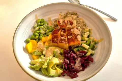 En färgglad bowl med lax, quinoa, edamamebönor, mango, avokado och rödbetor. Ett perfekt bowl recept för en hälsosam måltid.