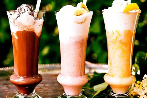 Tre läckra milkshakes i glas: choklad, jordgubb och aprikos. Perfekt för ett somrigt milkshake recept!