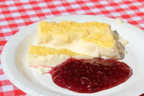 Två bitar krämig kalvdans med hallonsylt på en vit tallrik. Ett enkelt kalvdans recept för en härlig fika.