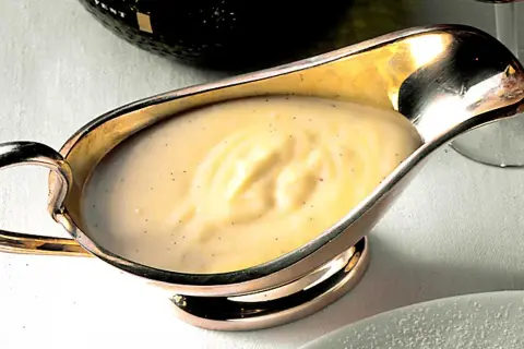 Krämig vaniljsås i silverkanna, perfekt för ditt vaniljsås recept. Smakrik och len.