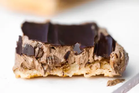 En närbild på en chokladbiskvi med krämig chokladfyllning och mörk chokladglasyr.