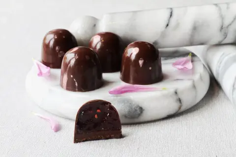 Chokladpraliner med glansigt skal, en skuren visar fyllning. Ett perfekt ganache recept till praliner.