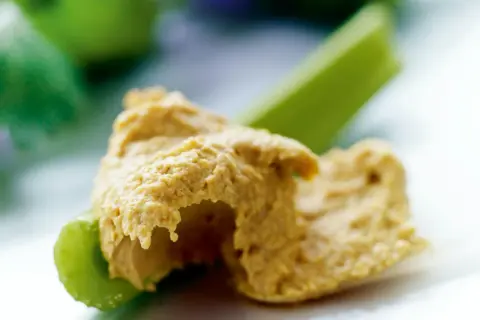 En klick krämig hummus på en krispig selleristjälk. Ett enkelt och gott recept på hummus som passar perfekt som mellanmål.